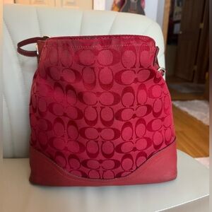 A very used, red coach bag. Well loved but has lots of life left.